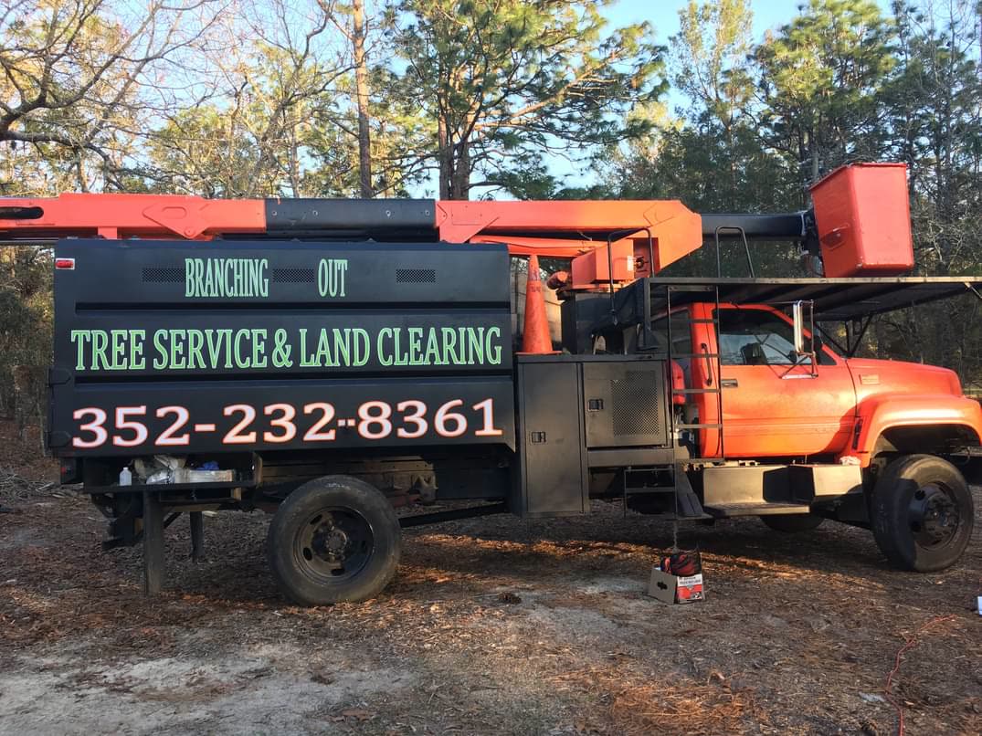 The Branching Out Tree Service and Land Clearing chip truck with its orange bucket
