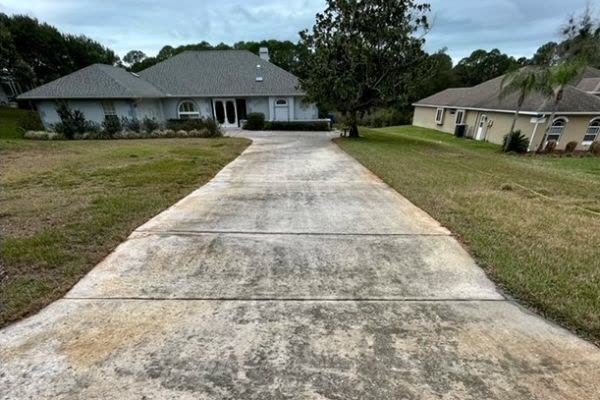 Long driveway before pressure washing, gray and stained