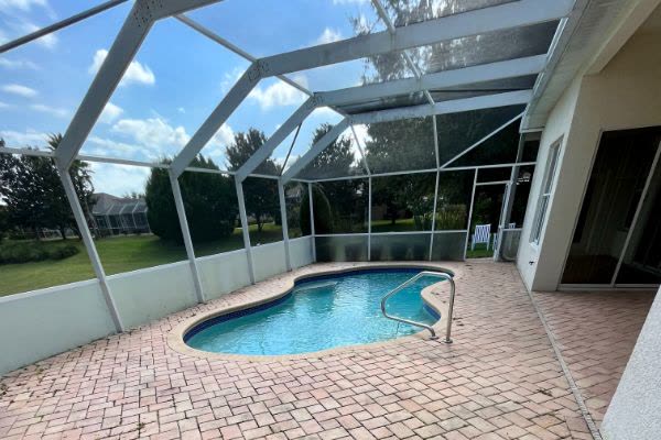 Clean pool cage and paver lanai around a pool