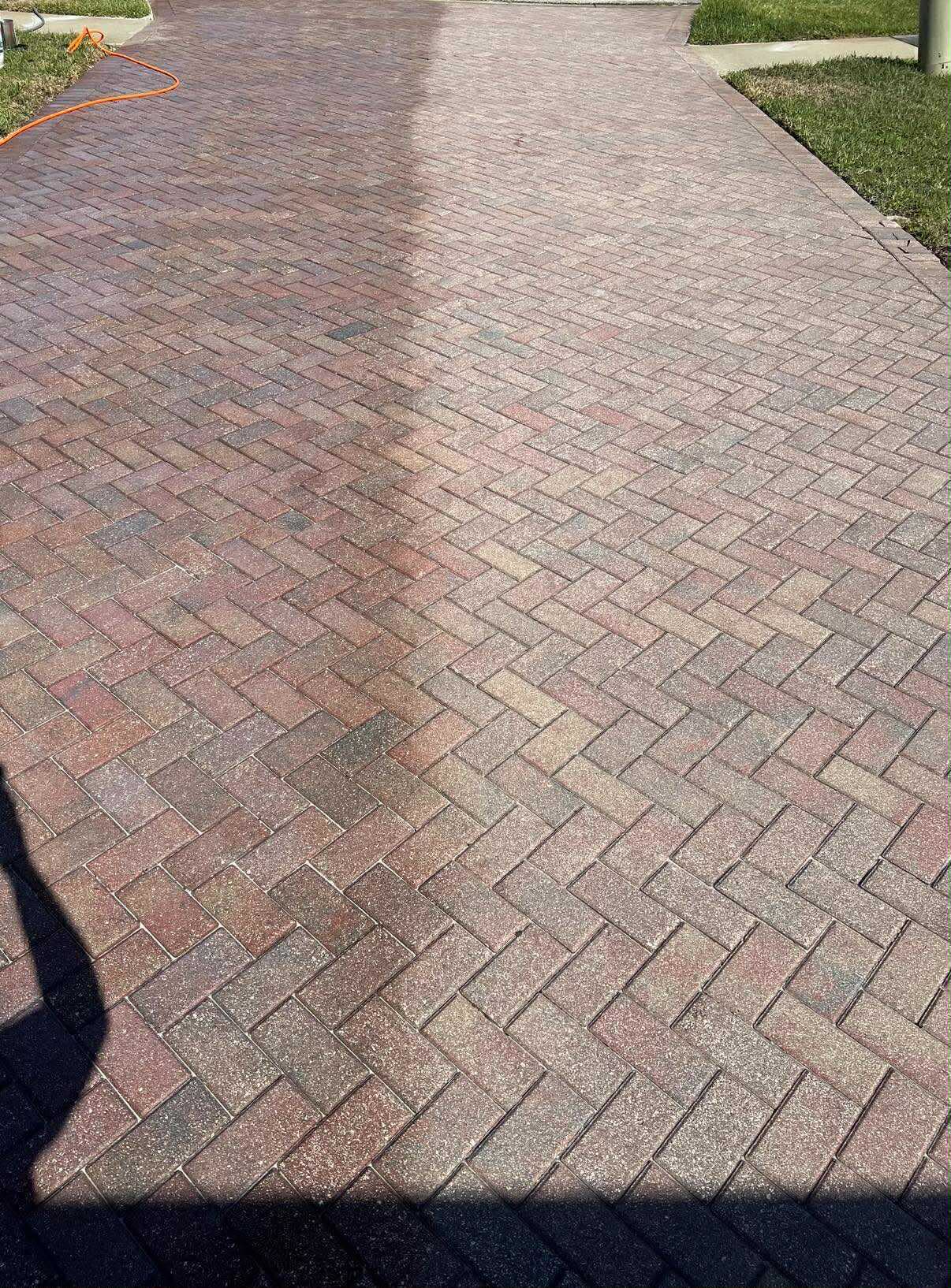 Red brick herringbone walkway part-way through a wash: the washed strip is bright red, the rest is still grey with grime